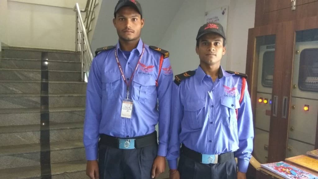Two IVS Security guards in uniform at a building lobby post