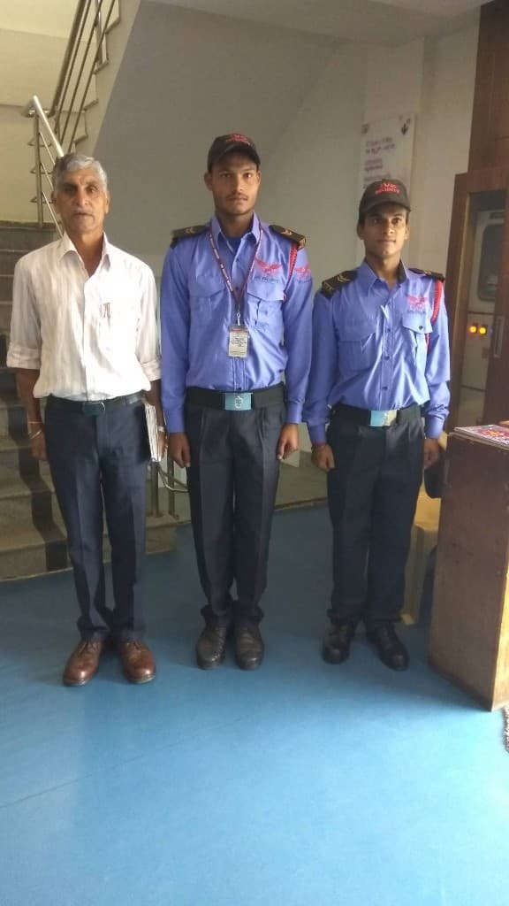 Supervisor standing with two IVS Security guards in an office lobby